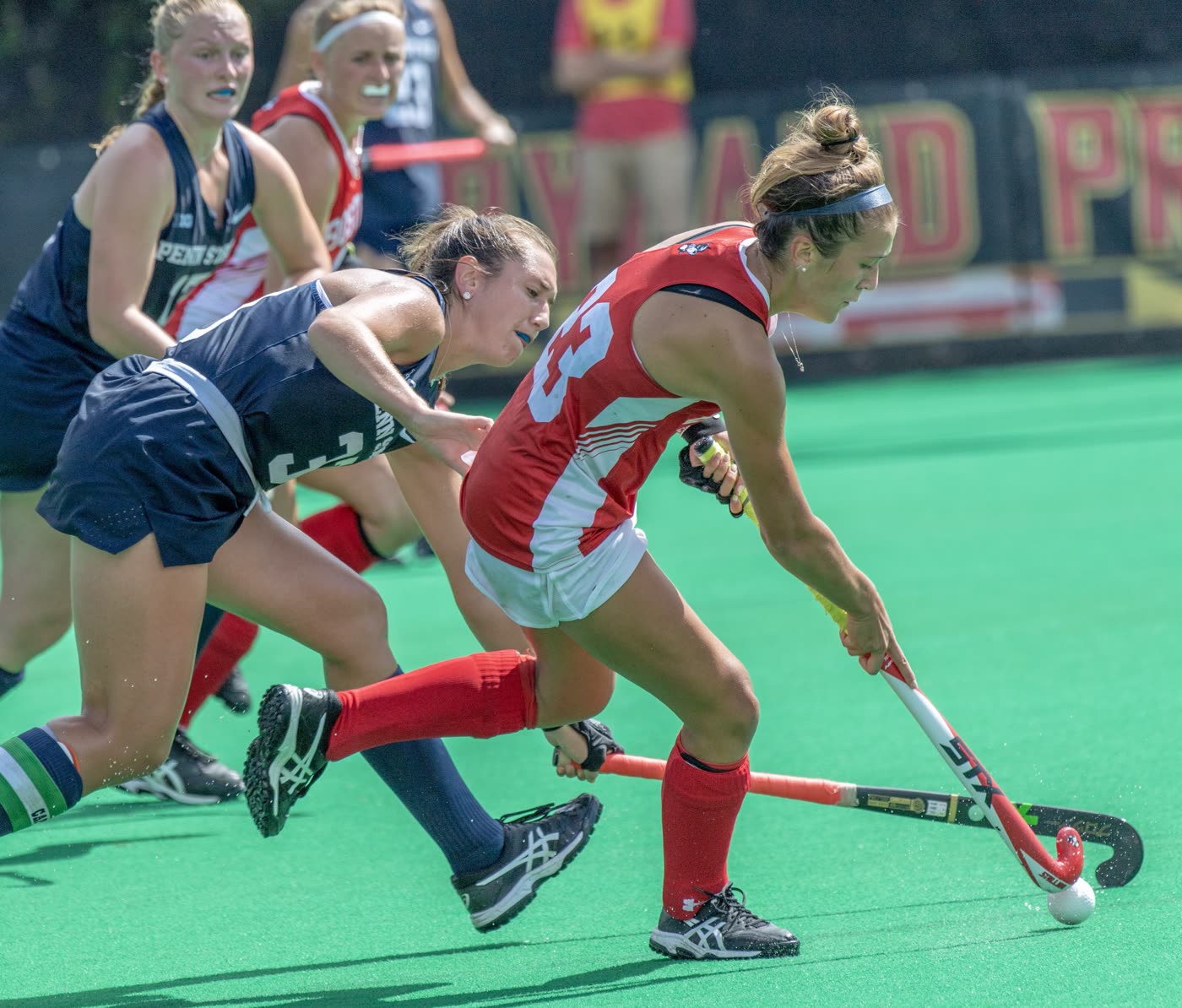 Boston University field hockey player driving past a defender